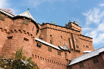 Fototapeta na wymiar Château alsacien du Haut-Koenigsbourg sous la neige en hiver. Vue extérieur sur la façade sud depuis le chemin d'accès