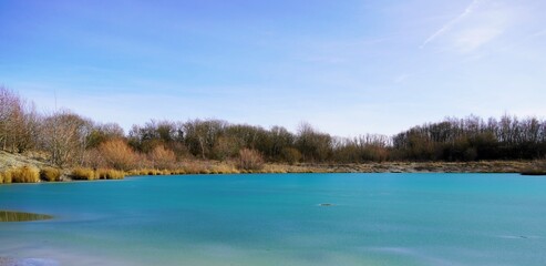 Blaue Lagune in Beckum, Nordrhein Westfalen. Gefrorener See, fotografiert im Winter bei sonnigem Wetter.