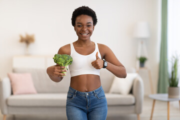 Happy Slim Black Woman Gesturing Thumbs-Up Holding Broccoli At Home