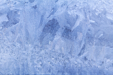 Blue frosty pattern on window glass. Winter background
