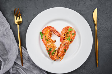 Two shrimps in shape of heart on the plate, top view. Love concept