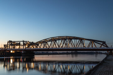 Dutch blue illuminated bridge, IJsselspoorbridge (Zutphen) over the high water of the river 'de ijssel'.