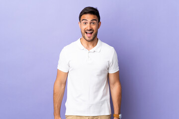 Young handsome man isolated on purple background with surprise facial expression