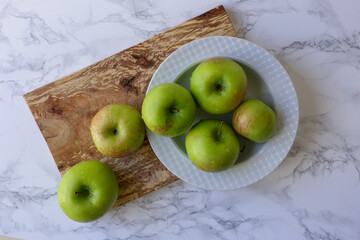 green, healthy apples in a white plate