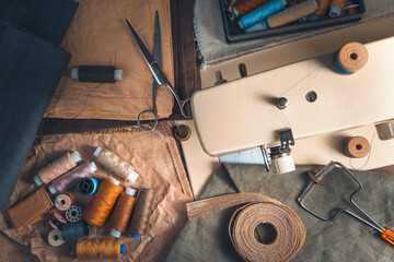 Sewing accessories and sewing machine on vintage background. Top view with blurred foreground. The concept of sewing.