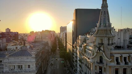 Aerial dolly left of El Molino coffeehouse tower and Argentine Congress building bronze cupola at sunset, Buenos Aires