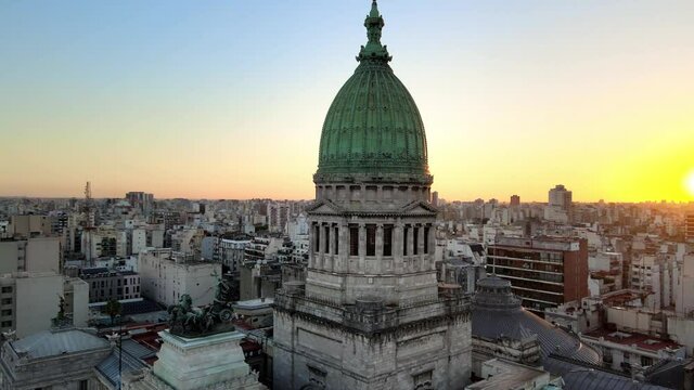 Aerial orbit around Argentine Congress building green bronze dome tower at sunset in Balvanera neighborhood, Buenos Aires