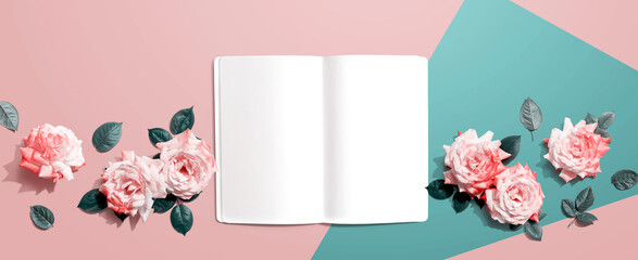 White blank notebook with pink roses overhead view - flat lay