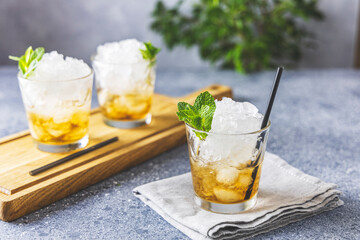 Homemade gourmet fresh Mint Julep alcoholic cocktail on light gray table surface