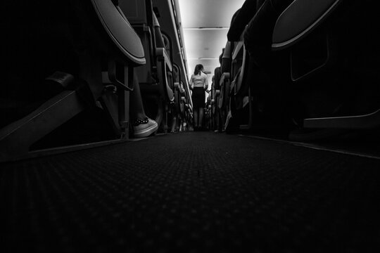 Sardinia, Italy, May 2020. Dramatic interior view of international flight during turbulence. Traveling during covid-19 pandemic, safety protocol, black and white perspective shot.  seasonal holidays.