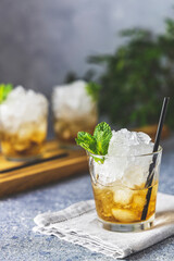 Mint Julep cocktail with bourbon, ice and mint in glass on light gray table surface