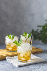 Cold summer beverage, mint julep cocktail drink, grey stone background copy space