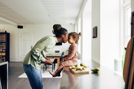 Loving mom and her little girl having a snack at home