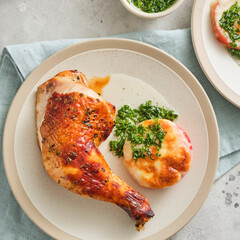 Fried chicken leg garnished with tomato and cheese.