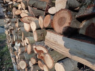 Wooden background. Firewood for the winter, stacks of firewood . Chopped wood logs for sale use in...