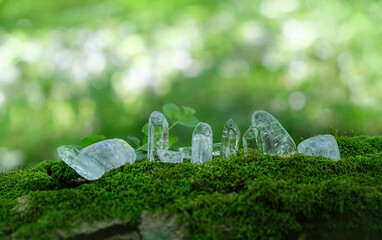 Clear crystal minerals on nature blurred background. Quartz gemstones for Meditation Reiki Kit....