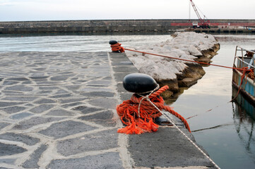 Focus on a bollard with a moored barge along the quayside.
