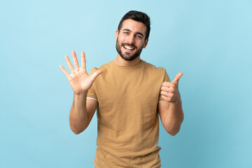 Young handsome man with beard over isolated background counting six with fingers