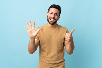 Fototapeta premium Young handsome man with beard over isolated background counting six with fingers