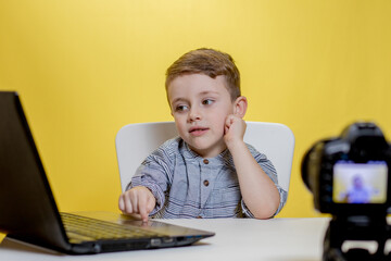 Child blogger videotapes his vlog at home. Boy recording his video blog. Little vlogger makes online streaming using camera