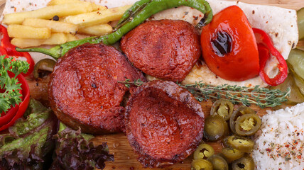 grilled sausage with fried potatoes, rice and salad
