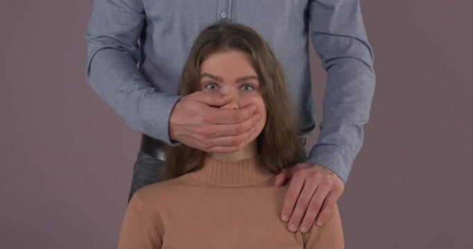 Caucasian couple. Unrecognizable man covering mouth of scared woman. Domestic violence. Abuse in relationship.
