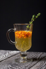 Cocktail with sparkling wine and sea buckthorn. Sea buckthorn bellini. Decorated with thyme sprigs.