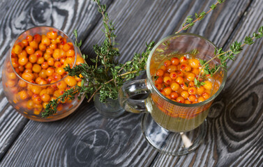 Cocktail with sparkling wine and sea buckthorn. Sea buckthorn bellini. Decorated with thyme sprigs.