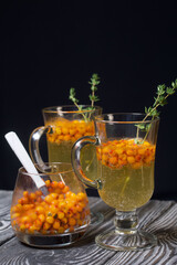 Cocktail with sparkling wine and sea buckthorn. Sea buckthorn bellini. Decorated with thyme sprigs.