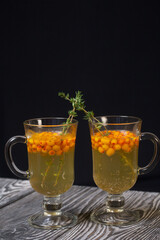 Cocktail with sparkling wine and sea buckthorn. Sea buckthorn bellini. Decorated with thyme sprigs.
