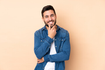 Fototapeta premium Caucasian handsome man isolated on beige background happy and smiling