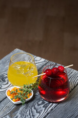 Sea buckthorn bellini with ice. Punch with cranberries. Garnished with thyme sprigs.