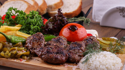 grilled meatballs with fried potatoes, rice and salad