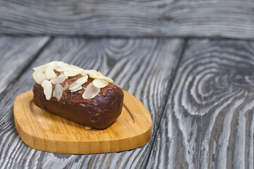 Potato cake. Decorated with almond petals and chocolate cream.