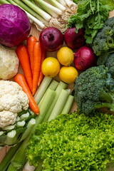 Vegetables for healthy eating carrots, leeks, cauliflower, lettuce, purple cabbage, purple onion, lemon, broccoli stand on the table