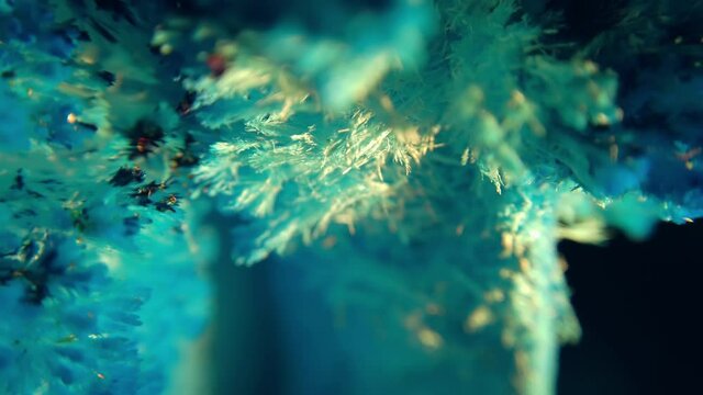 Macro of rotating pile of blue salt crystals. Abstract background of the movement of shining blue crystal particles
