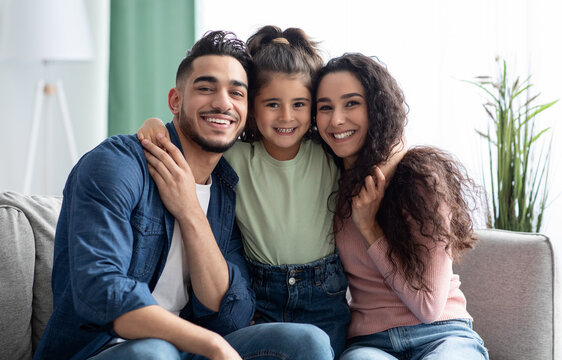 Happy Family Portrait. Smiling arabic parents and their little daughter posing together