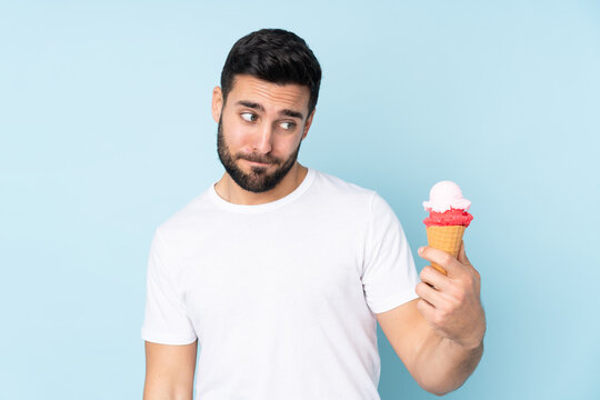 Caucasian Man With A Cornet Ice Cream Isolated On Blue Background With Sad Expression