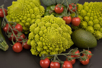 fresh vegetable, romanesco broccoli, pepper, zucchini and avocado, free space in your text, on a black table