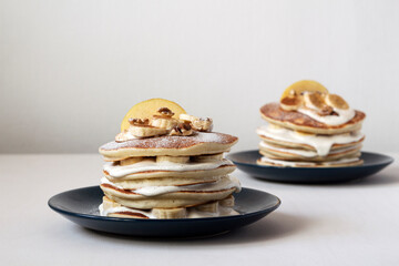 Tasty breakfast. American pancakes with butter cream, apple, bananas, walnuts and cinnamon.