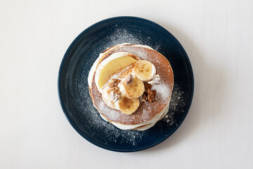 Tasty breakfast. American pancakes with butter cream, apple, bananas, walnuts and cinnamon.