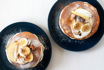 Breakfast for two. American pancakes with apple, banana and walnuts.