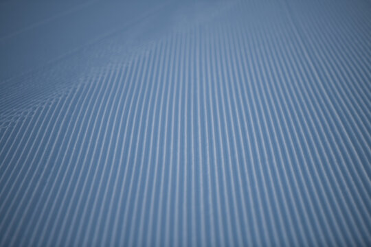 close up of corrugated lines in snow made by cat groomer grooming trails for winter outdoor sports nordic and alpine or downhill skiing in fresh snow on winters day outside in cold temperatures 