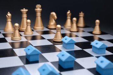 Blue miniature houses property development strategy planning on chess board. Property management....