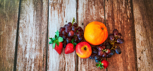 Fresh fruit that lies decoratively in the sunlight on a wooden table.