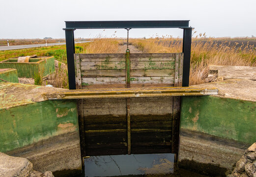Wooden gates in an irrigation ditch, to measure the entry and exit of the water flow from the rice fields.