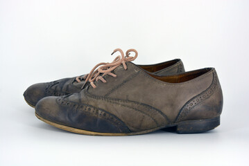 Female leather shoes located on a white background. Oxford shoes with gray shoelaces on a flat heel. Gray women's shoes in a fastening, unwitting. 