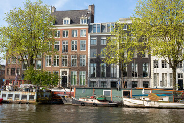 Fototapeta na wymiar Europe, Netherlands, Amsterdam. Boats and houses along canal.