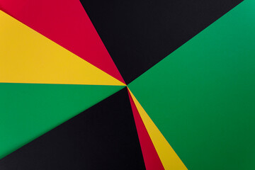 Red, yellow and green colors papers on the black background. Black History Month concept. Flat lay....