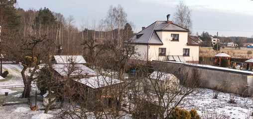A chimney sweep cleans the chimney on the roof of a detached house
